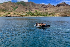 En fyldt dinghy med folk der skal i land